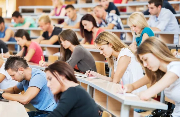 Studenten sitzen im Hörsaal und schreiben eine Prüfung